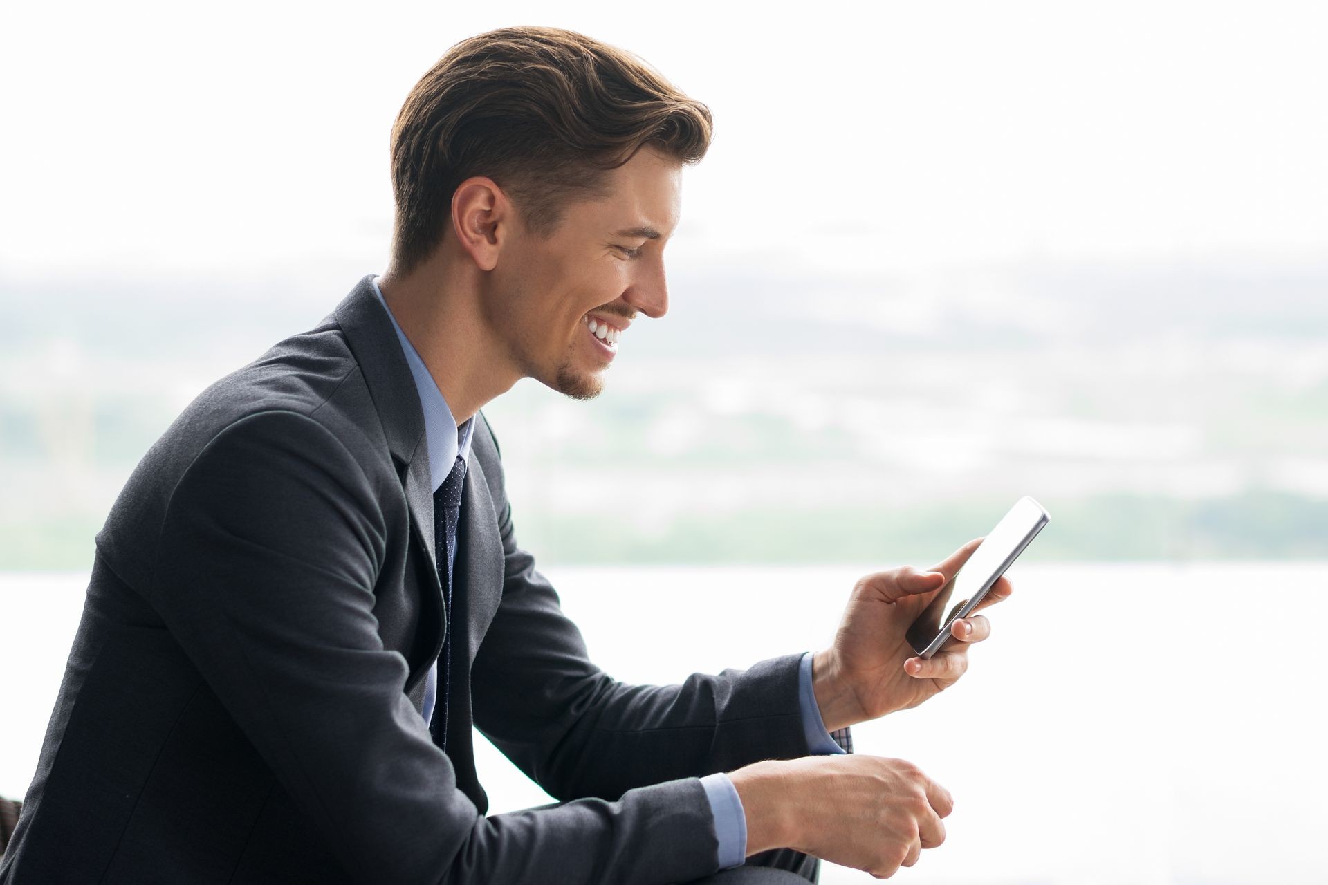 Smiling Middle-aged Businessman Using Smartphone